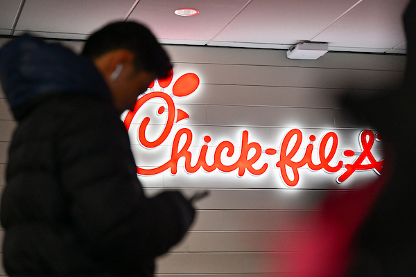 Student walking past red Chick-fil-A logo