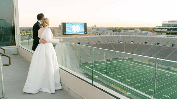 Bride and Groom on the stadium terrace overlooking the football field.