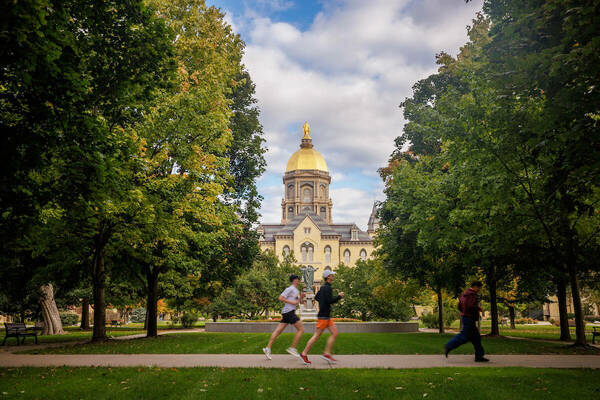 Two runners on a pathway in front of Main Building