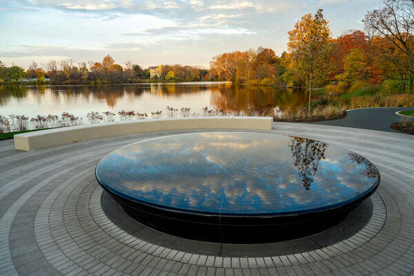 Infinity fountain at Our Lady of the Lake World Peace Plaza overlooking St. Mary's Lake with fall foliage