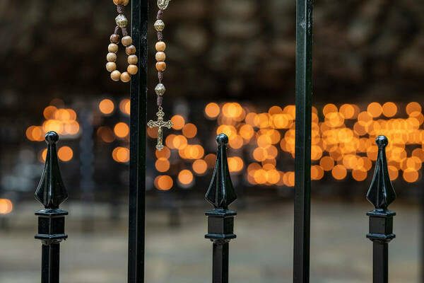 Rosary Beads hung on the rungs by the kneelers at the Grotto
