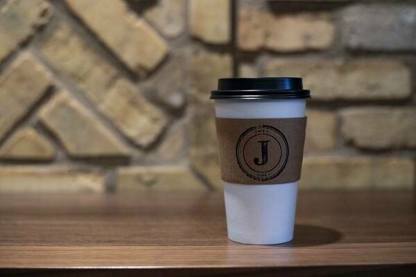 White coffee to-go cup with Café J sleeve