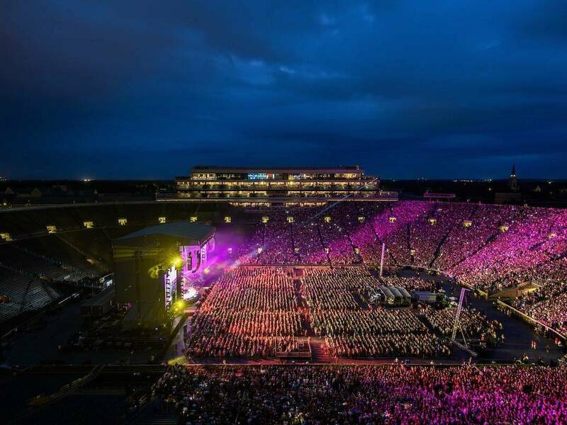 Notre Dame Stadium with a dark night sky and purple spotlights on the crowd filled stadium for the Billy Joel concert
