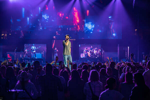 Walker Hayes performing in Joyce Center with purple lights over the crowd