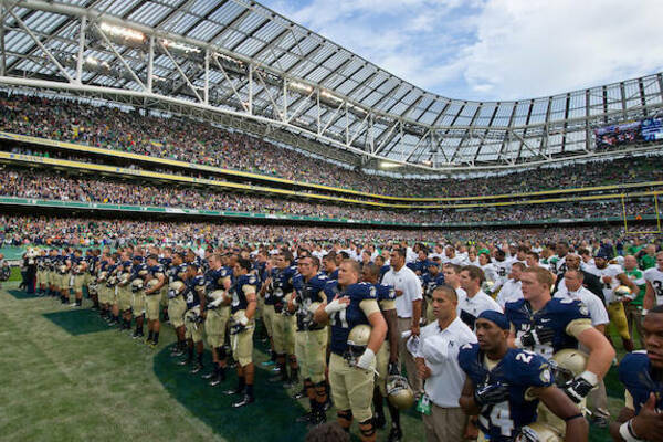 Navy Football Players in a line with hands over hearts during their Alma Mater