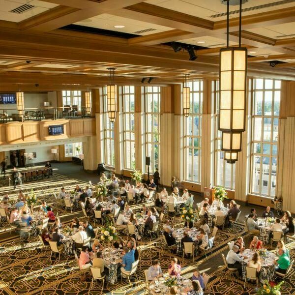 Ariel view of an event being held in Dahnke Ballroom inside of the Duncan Student Center. Tables with guests fill the room.