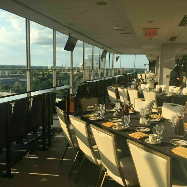 Seven on 9 event space decorated for an event. The space includes tables, place settings and chairs overlooking the stadium.