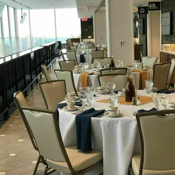 Seven on 9 event space decorated for an event. Tables with white tablecloths and classy place settings fill the space.