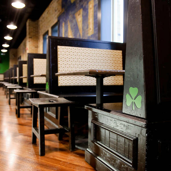 Close up angle of the booths in O'Brien's. Stools line the edges of the booths to fit an additional guest.