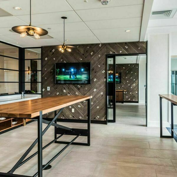 Southwest 9 event space. The space includes a big table for food and stadium chairs with a view of the stadium. Modern touches like black iron and refurbished wood give this space an elevated feel.